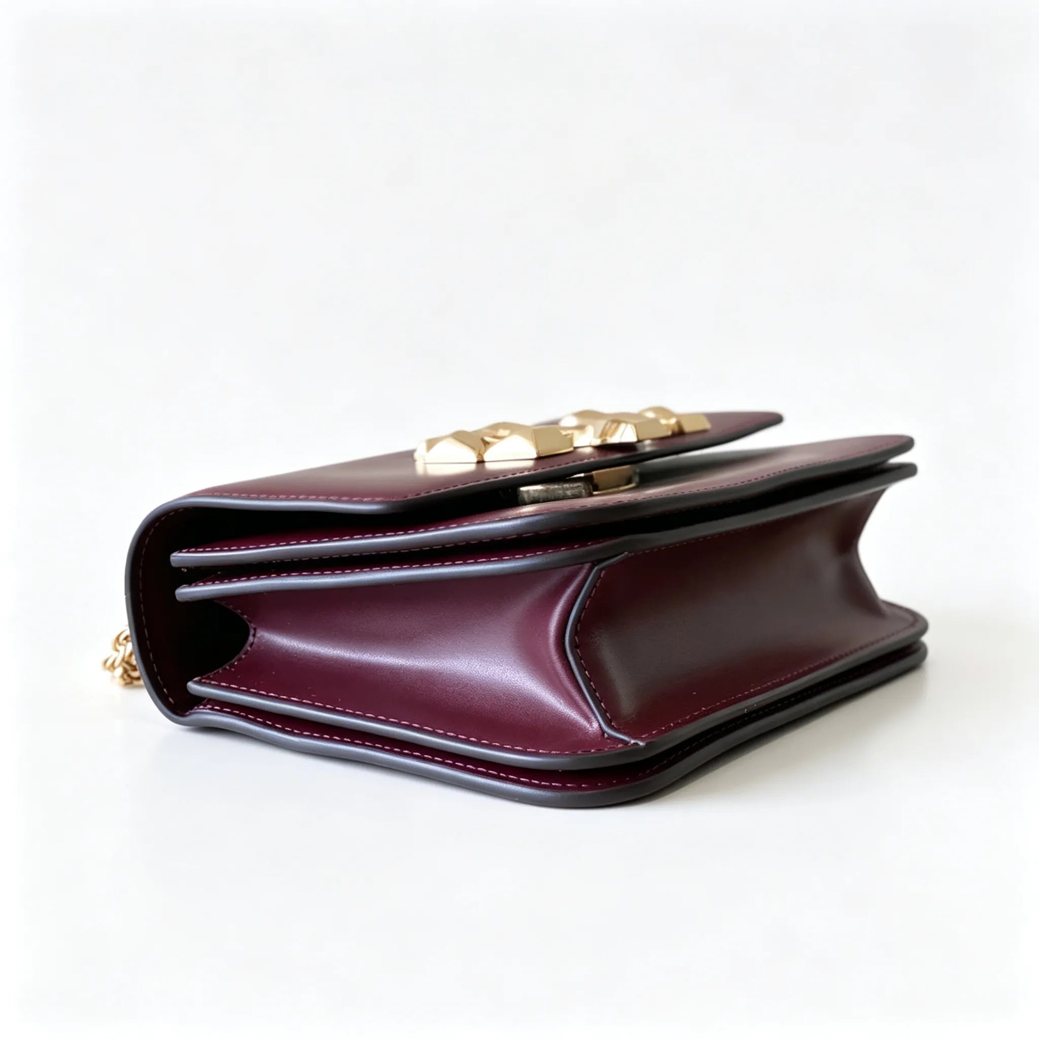 Tory Burch Eleanor burgundy with a gold double-T adjustable twist chain shoulder strap offering multiple carrying options for women