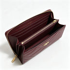 Tory Burch Kira burgundy quilted Nappa leather clutch with multiple card slots and a zippered coin purse