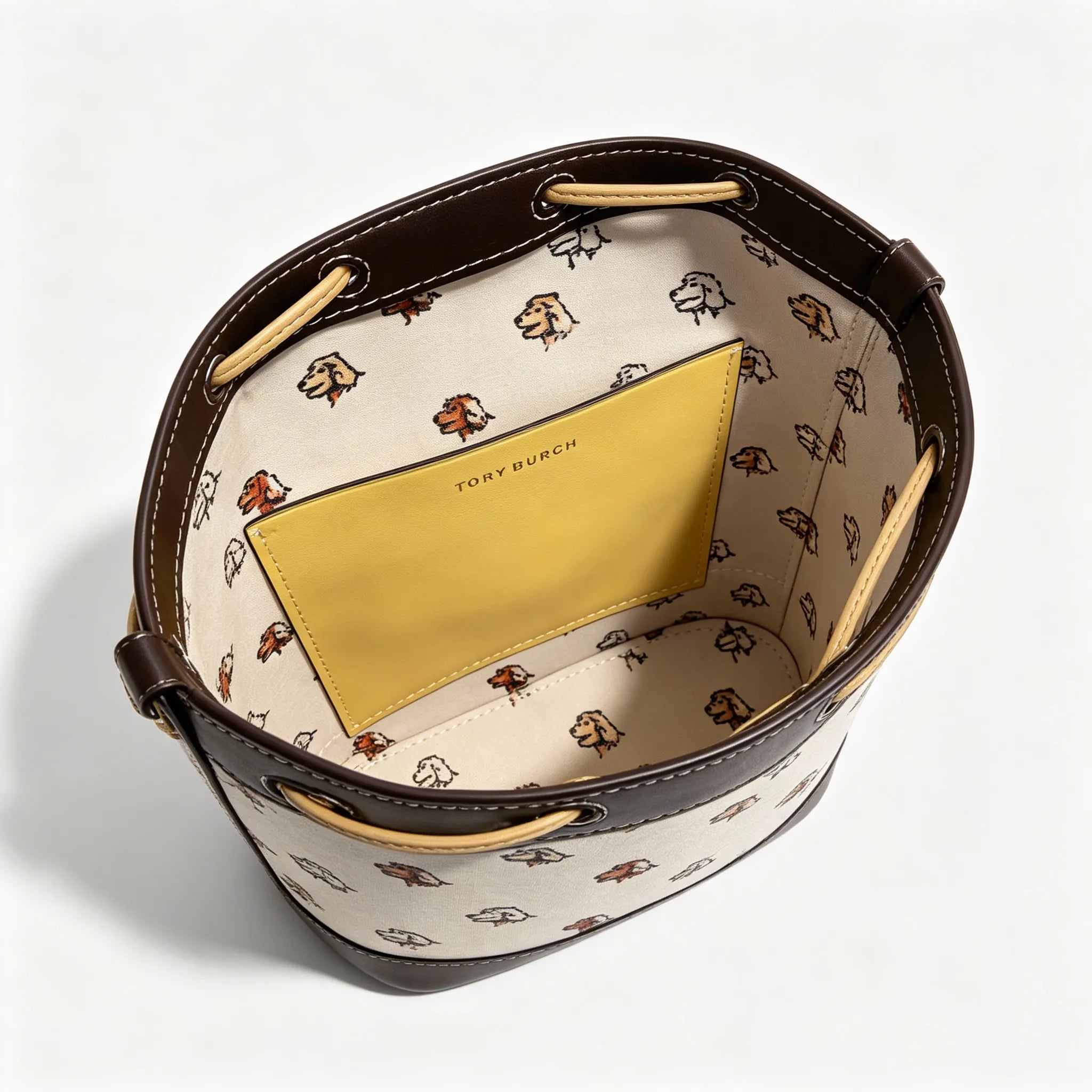 Tory Burch T Monogram | Off-white base with hazelnut brown monogram jacquard pattern and dark brown leather trim  drawstring closure versatile handbag suitable for commuting and travel