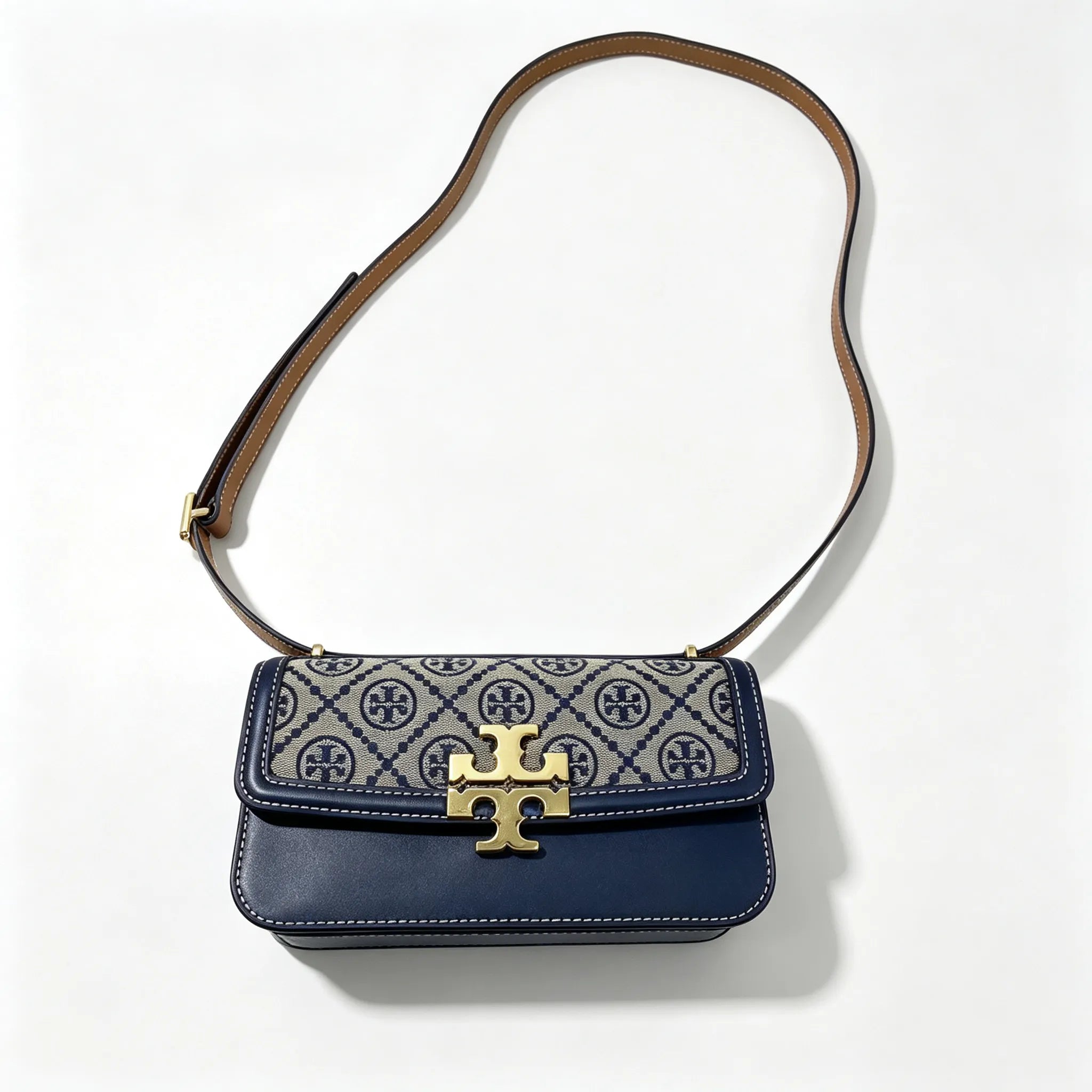 Tory Burch navy and beige Monogram canvas with an adjustable leather shoulder strap convertible into a crossbody or shoulder bag women's style