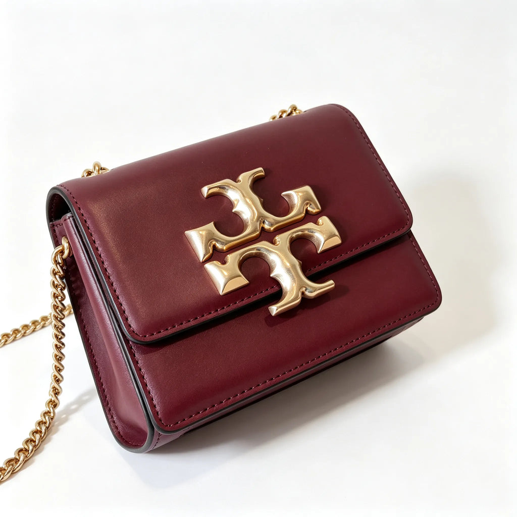 Tory Burch Eleanor burgundy with a gold double-T adjustable twist chain shoulder strap offering multiple carrying options for women