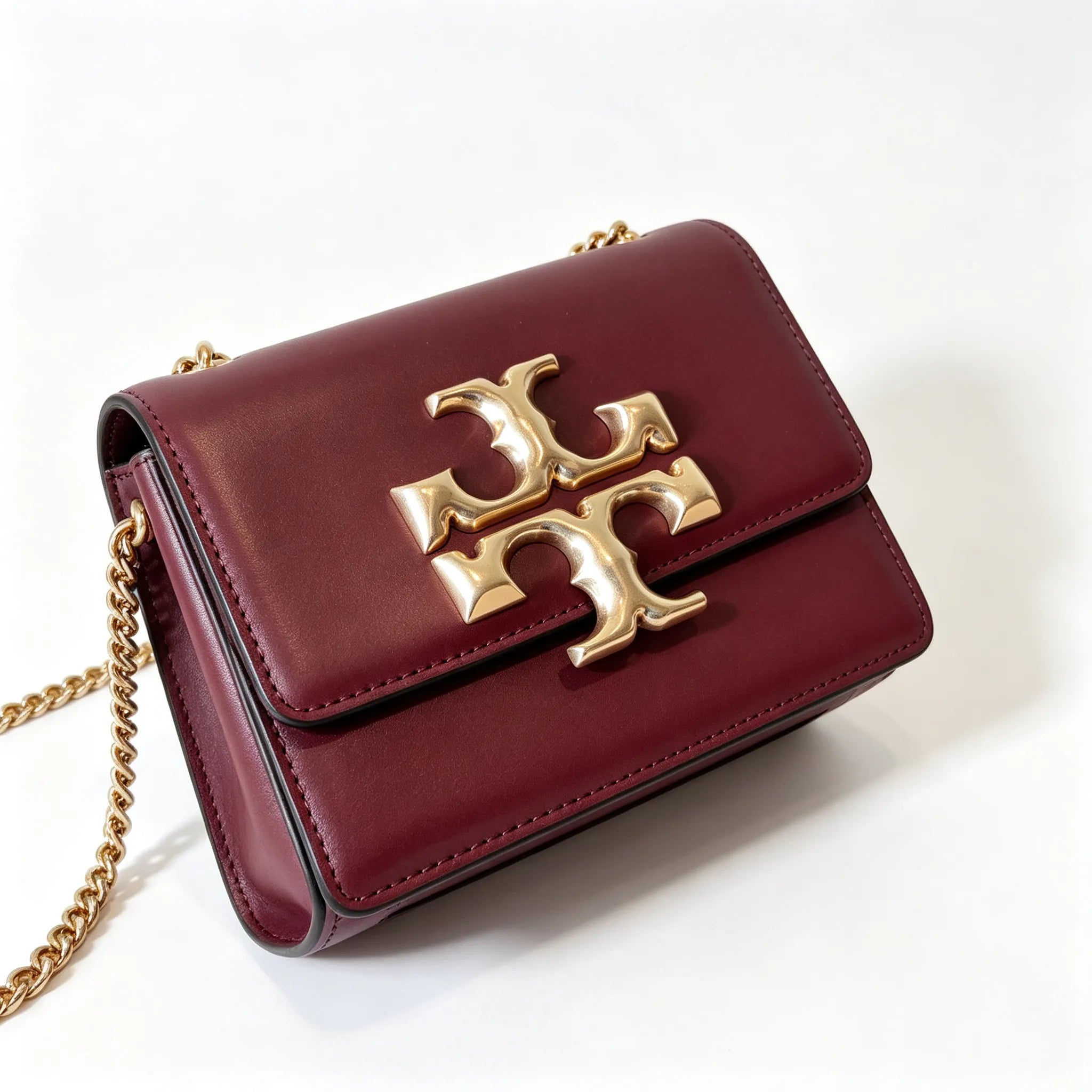 Tory Burch Eleanor burgundy with a gold double-T adjustable twist chain shoulder strap offering multiple carrying options for women