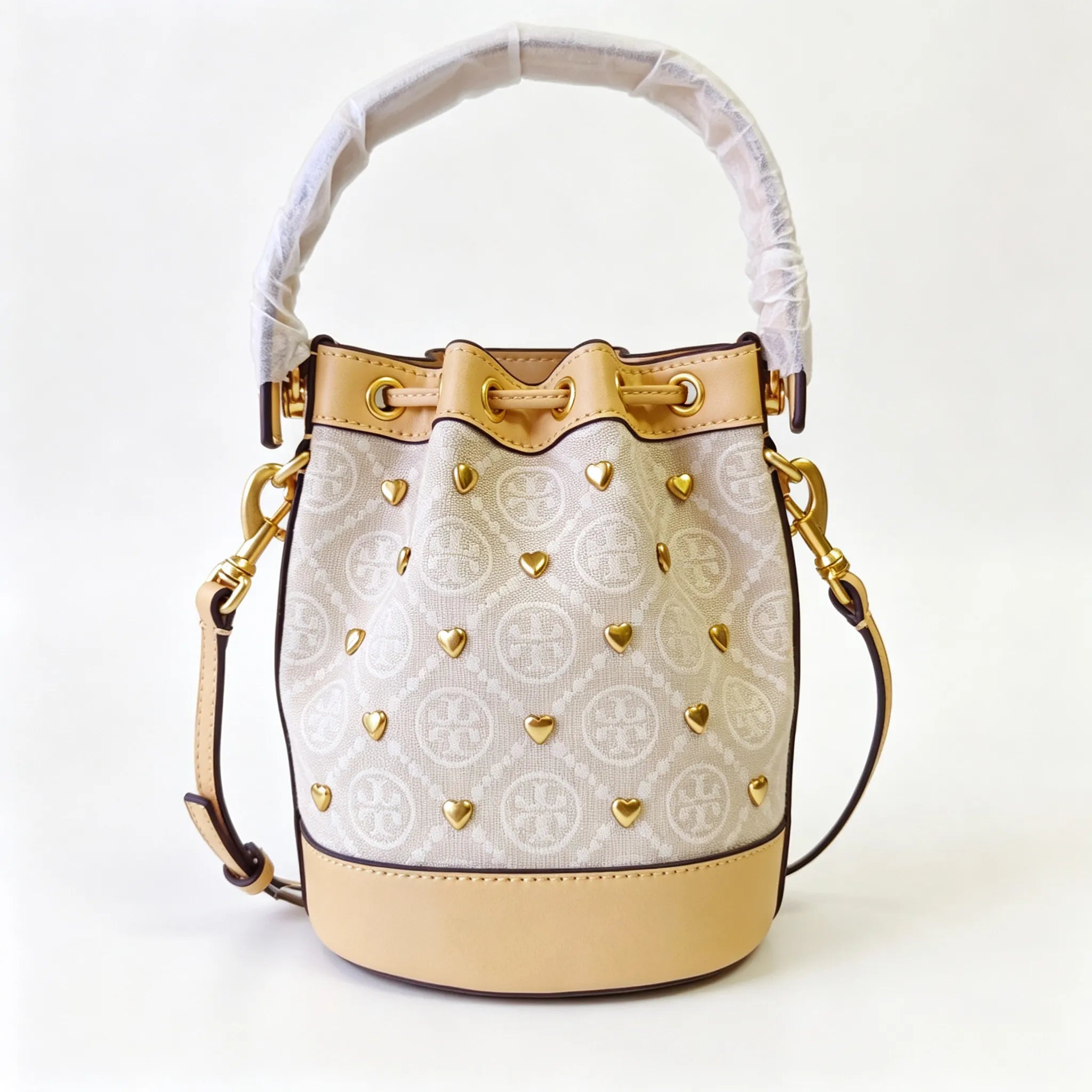 Tory Burch T Monogram ivory and beige Monogram canvas adorned with gold heart studs drawstring closure and detachable shoulder strap women's designer handbag