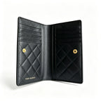 Tory Burch Fleming black quilted leather clutch with multiple card slots and a zippered coin pocket
