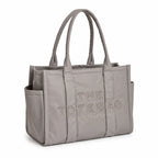 Marc Jacobs | Grey quilted nylon  embossed logo  double handles  exterior pocket  women's commuter tote bag