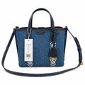 Tory Burch Perry | Blue washed denim  white embroidered T-logo stripes  navy leather trim and gold charm  double handles and adjustable shoulder strap  women's designer shoulder bag