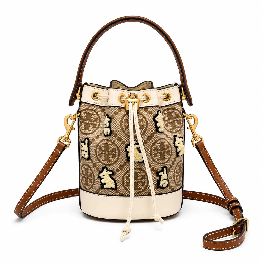 Tory Burch T Monogram | Hazelnut brown Monogram fabric beige leather trim adjustable shoulder strap drawstring closure limited edition women's mini rabbit embroidered bucket bag