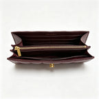 Tory Burch Kira burgundy quilted Nappa leather clutch with multiple card slots and a zippered coin purse