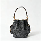Tory Burch | Dark washed denim bucket bag with side pockets and drawstring closure featuring a T-print pattern